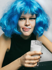 Girl drining milk Girl in a blue wig drinking milk from a glass Close-up