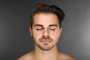 Obraz premium Portrait of young handsome man on grey background