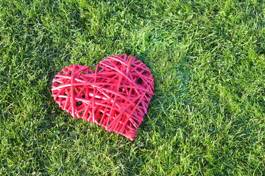Red straw heart on the grass. Valentine's Day. 