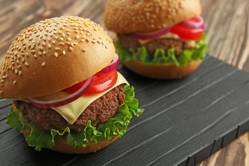 Delicious cheeseburgers on wooden background