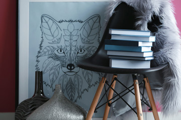 Design interior with stack of books on chair