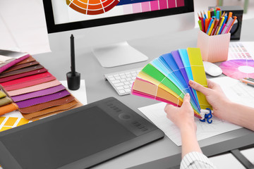 Young designer choosing color of interior while working in office, closeup