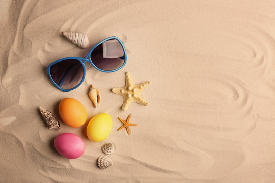 Easter eggs with sunglasses on sand