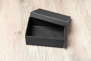 Black empty box on wooden background