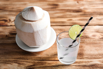 Coconut water and fresh nut on wooden background