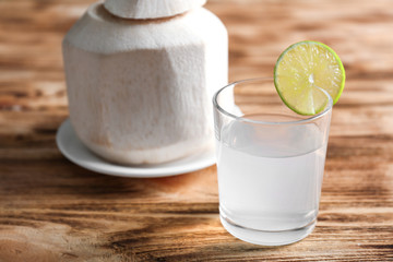 Coconut water and fresh nut on wooden background