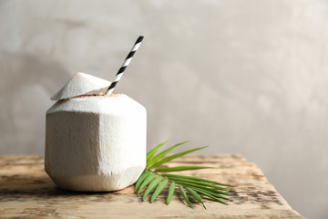 Coconut cocktail with straw on wooden table