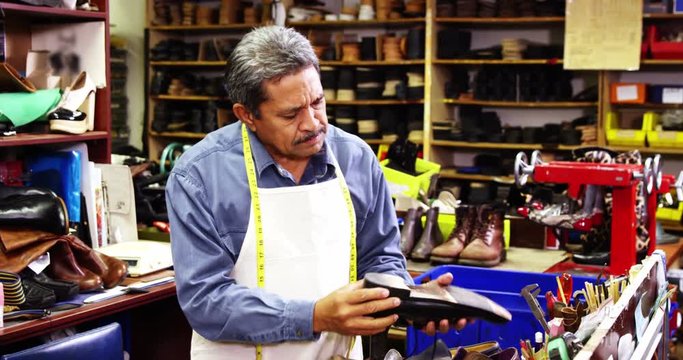 Cobbler making shoes with a hammer in workshop 4k