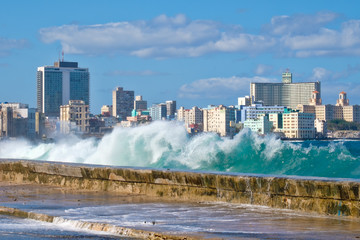 The Havana skyline with waves crashing on the Malecon seawall - obrazy, fototapety, plakaty
