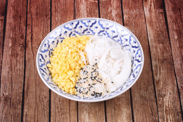 Streamed mung bean topped roll coconut  with sesame in sugar .