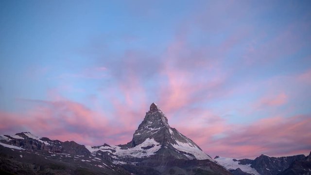 dawn, sunrise time lapse of the amazing matterhorn mountain in the Swiss Alps. the sky lights up in an incredible display of colour followed by the shadow lowering over the mountain