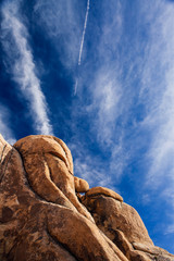 Large granite outcrop stands in the California desert under an intense blue sky