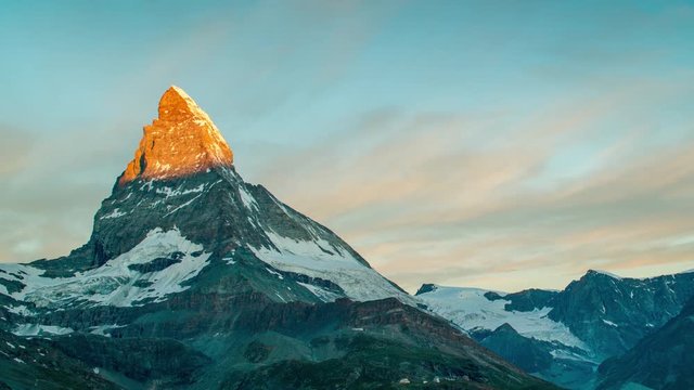 dawn, sunrise time lapse of the amazing matterhorn mountain in the Swiss Alps. the sky lights up in an incredible display of colour followed by the shadow lowering over the mountain