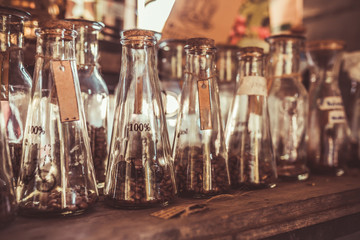 Collection of roasted coffee beans glass jar on old wooden shelf in vintage style.