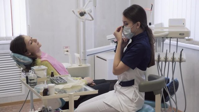 beautiful female dentist prepares the patient to the procedures in the dental clinic. Concept of heatlhy life.