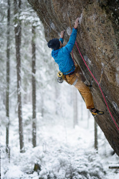 Rock climber, professional athlete, climbing in Karelian mountains. Extreme sports. 