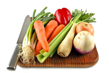 Vegetables on a chopping board with a knife ready for preparation