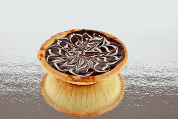 Caramel tart on a reflective surface