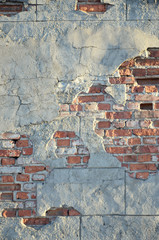 Weathered stained brick wall with cracked cement tension