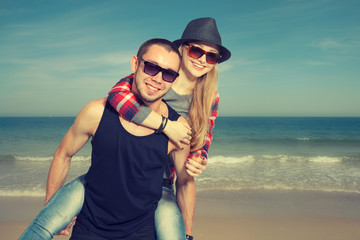 Happy loving couple having fun on the beach against the sea..