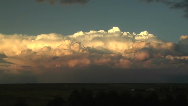 Storm Clouds Illuminated by Setting Sun on Plains