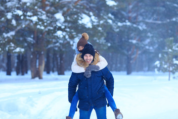 Fototapeta premium Playful couple walking outdoors in snowy woods