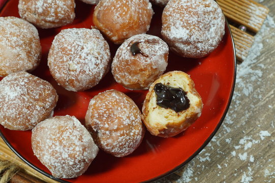 Sweet donuts on the red plate.. Fat Thursday Slavic culture 
