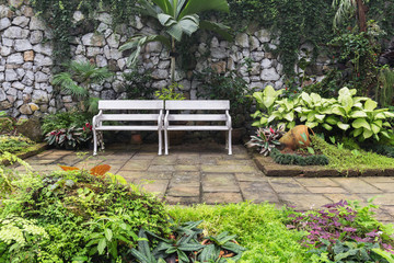 Two white benches inside garden