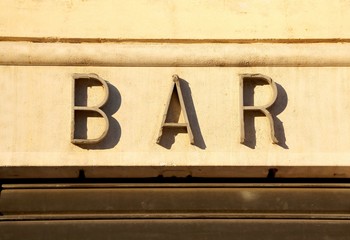 sign of BAR in big letters on the wall of the building