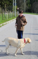little boy with his dog on a leash on the way