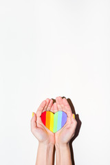 Rainbow painted heart in open palms