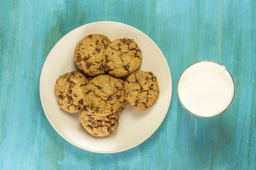 Chocolate chips cookies with glass of milk, shot from above