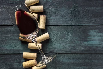 Gordijnen Glas rode wijn en kurken op donkere achtergrond © laplateresca