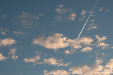 .Blue sky with clouds thin morning plane trip away. White smoke