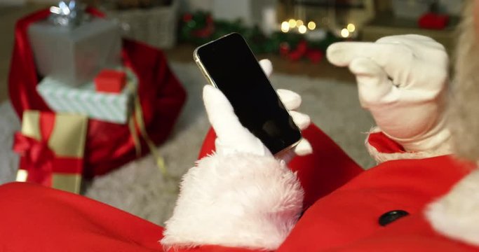 Close-up of santa claus using mobile phone during christmas time at home 4k