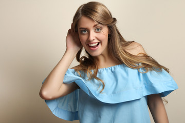 Fototapeta premium Beautiful girl with long wavy hair holds a hand near the ear.