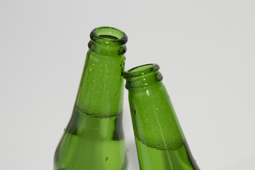 Two green beer bottles on white background