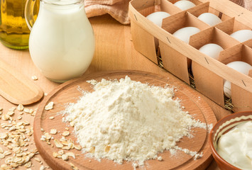 ingredients for making pancakes and pancakes on a wooden table