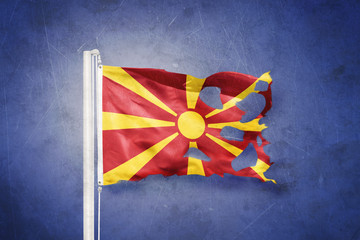 Torn flag of Macedonia flying against grunge background