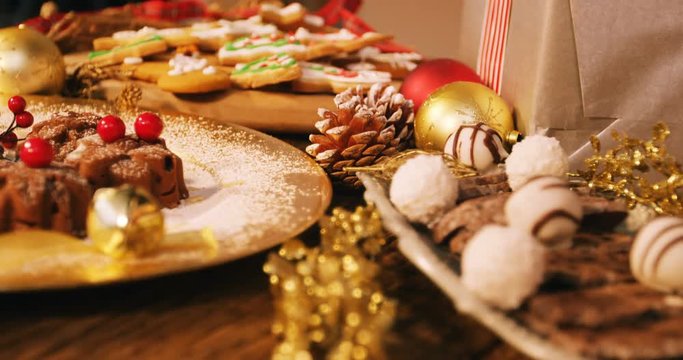 Close-up of various christmas desserts and gifts on wooden table 4k