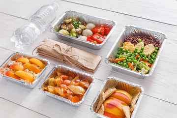 Healthy food take away in boxes, top view at wood