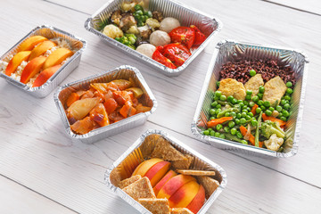 Healthy food take away in boxes, top view at wood