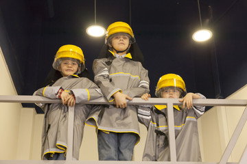 Fototapeta premium Three boys dressed like firefighters