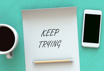 KEEP TRYING, message on paper, smart phone and coffee on table, 3D rendering