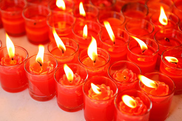 Red candles burning in glass