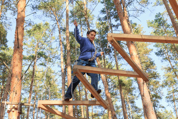 Gomel, Belarus - OCTOBER 5, 2014: Rope town for a family holiday in the countryside. Family competition to overcome aerial obstacles.