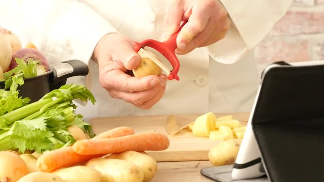 closeup of hands peeling potatoes