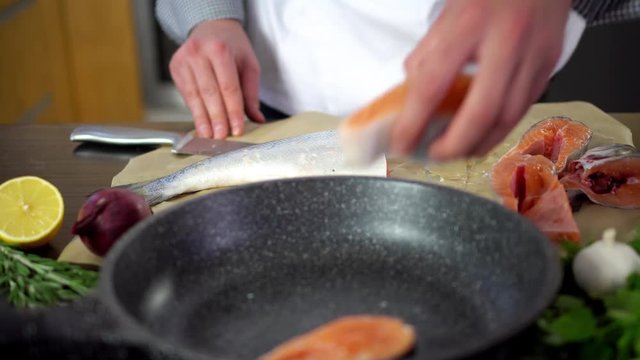chef putting salmon fish on pan for cooking