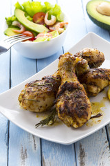 Grilled chicken legs fried tomatoes vegetables fresh salad avocado spices food in the kitchen
