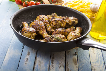 Grilled chicken legs fried tomatoes vegetables fresh salad avocado spices food in the kitchen

